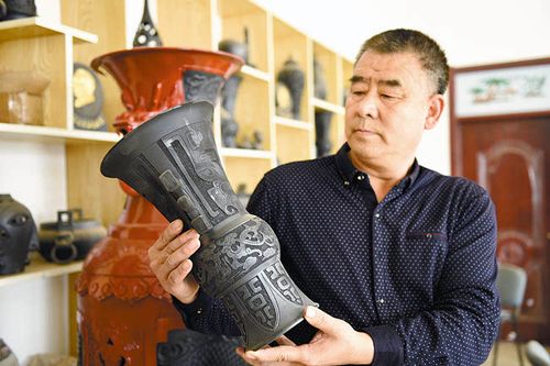 图为河北省工艺美术大师申振英展示自己的黑陶工艺品.